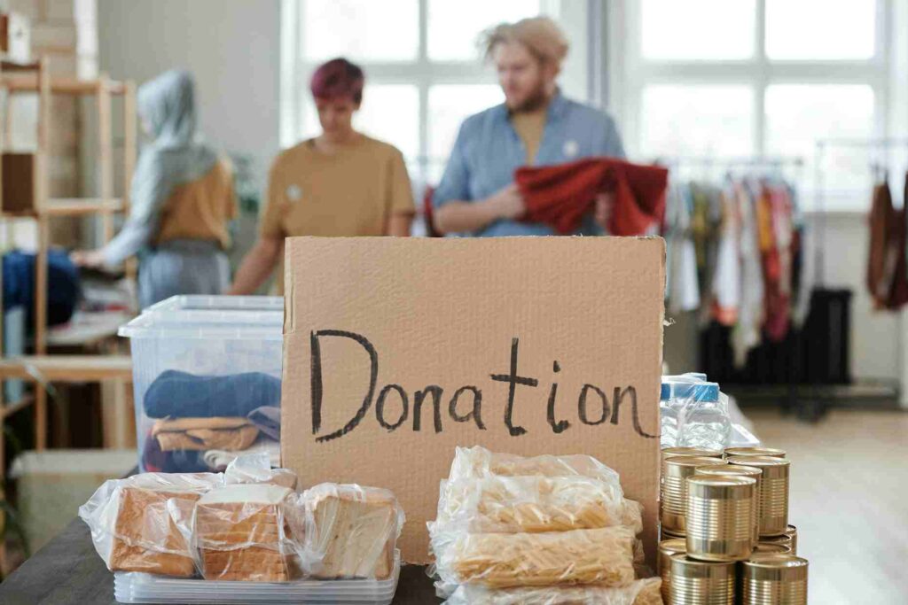 Charity donation table with food, clothes, and canned goods prepared for people in need