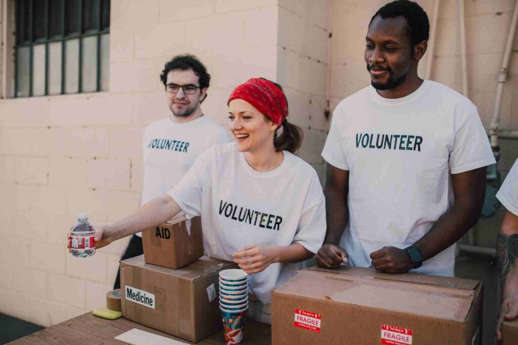Volunteers distributing food, water, and medicine to people in need during a charity relief program