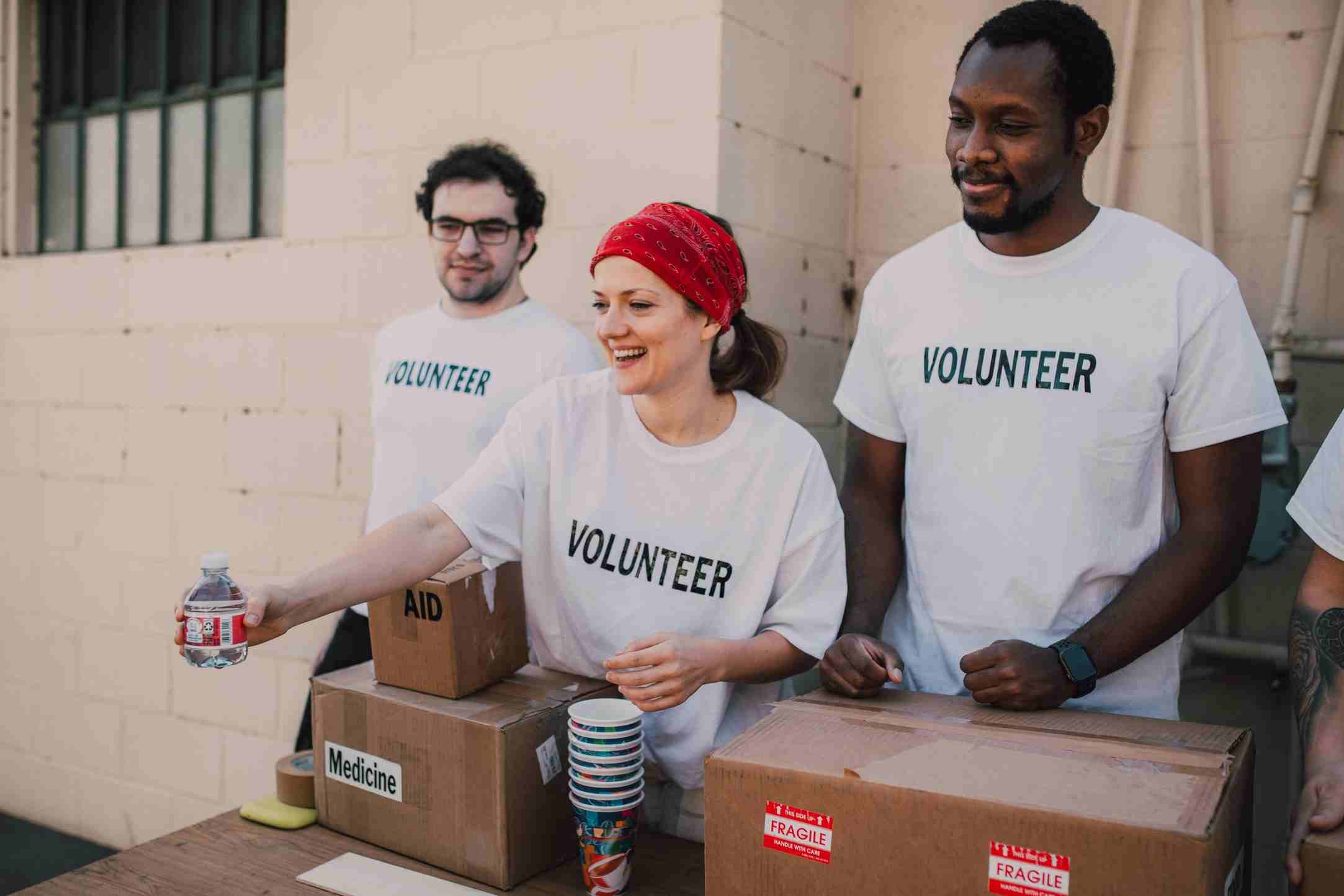 Volunteers distributing food, water, and medicine to people in need during a charity relief program